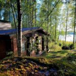 Pieni saunamökki järven rannalla.